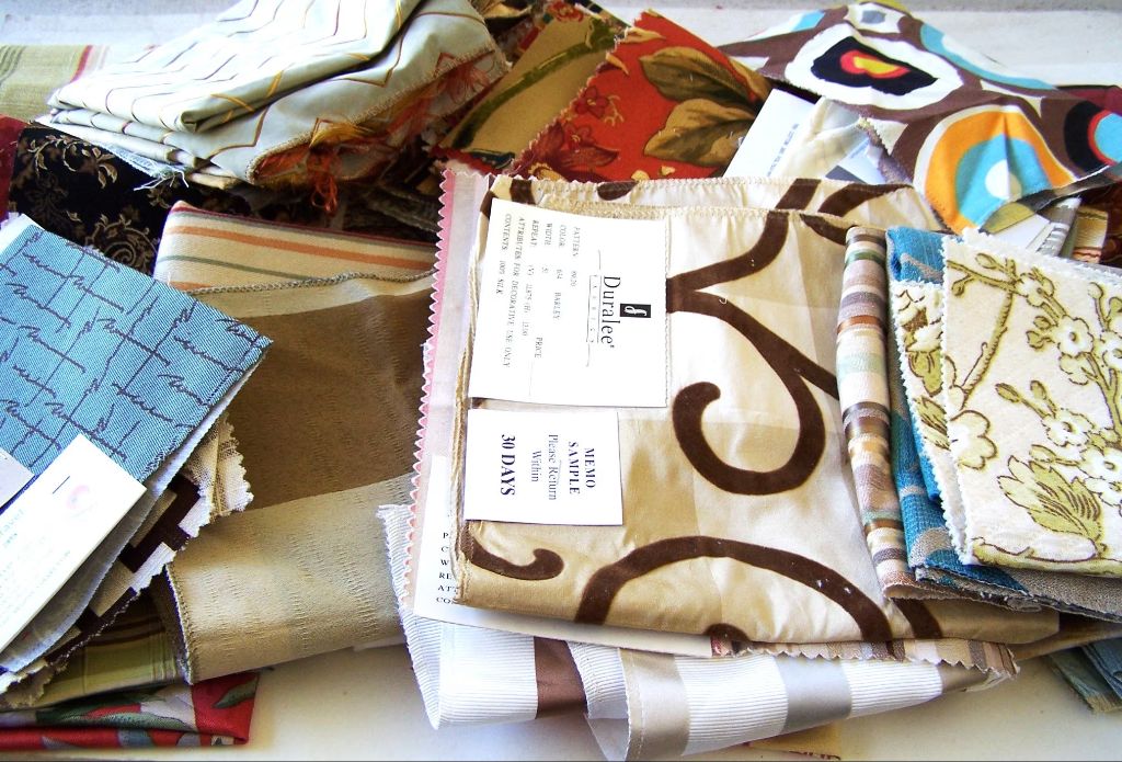 a photo of various fabric swatches laid out on a table to showcase different materials like cotton, polyester, wool, silk, etc.