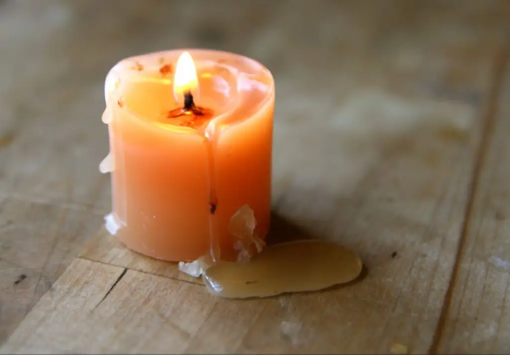 hardened candle wax being scraped out of a jar