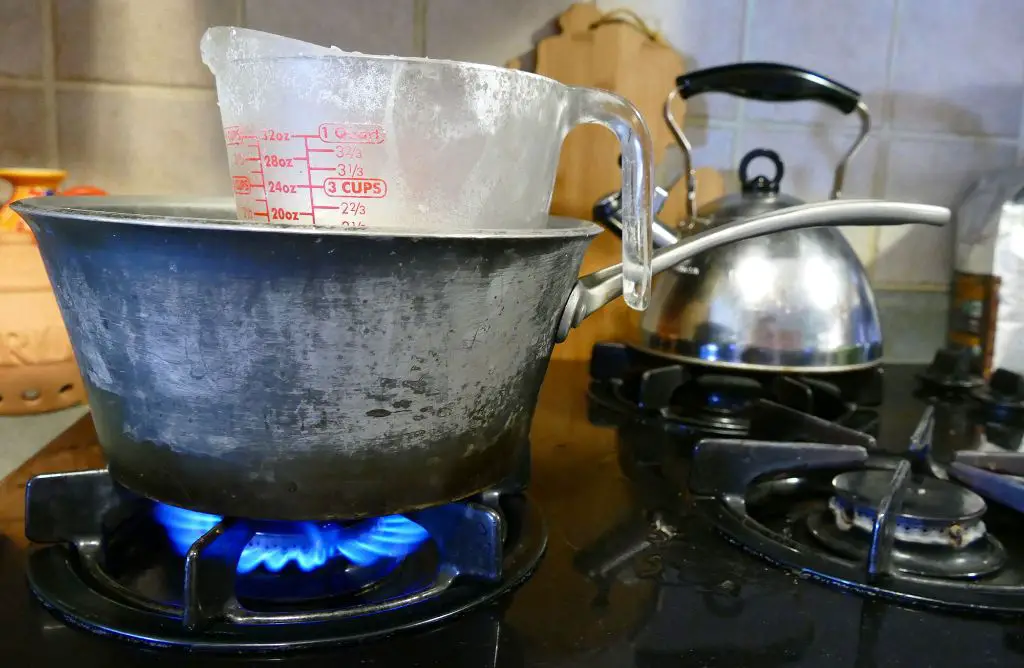 melting wax in a double boiler on the stove before pouring into containers.