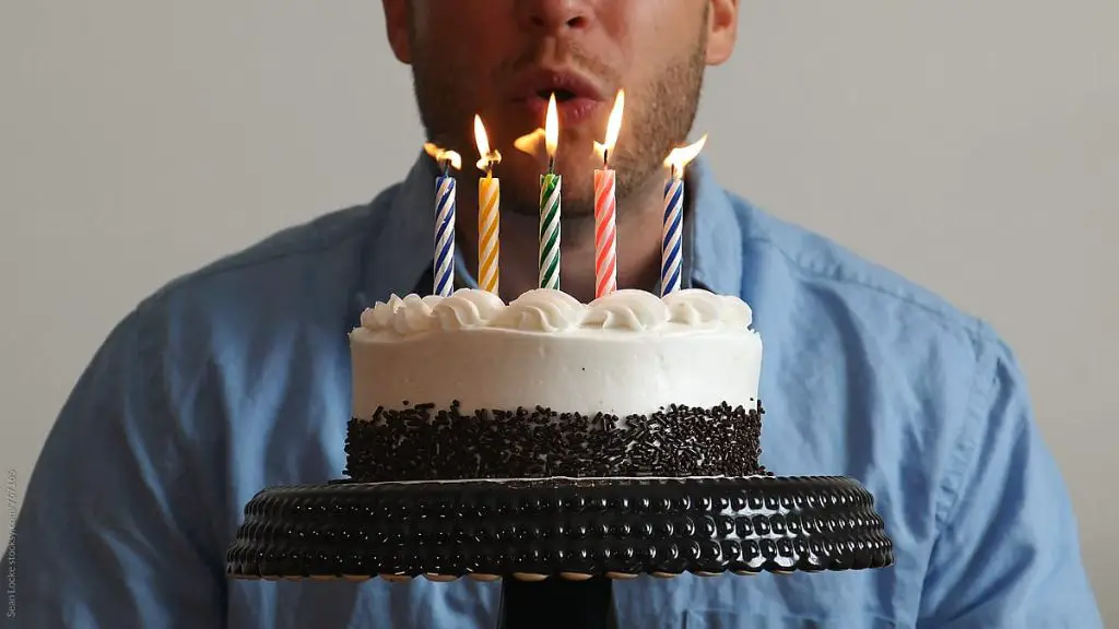 person blowing out a candle.