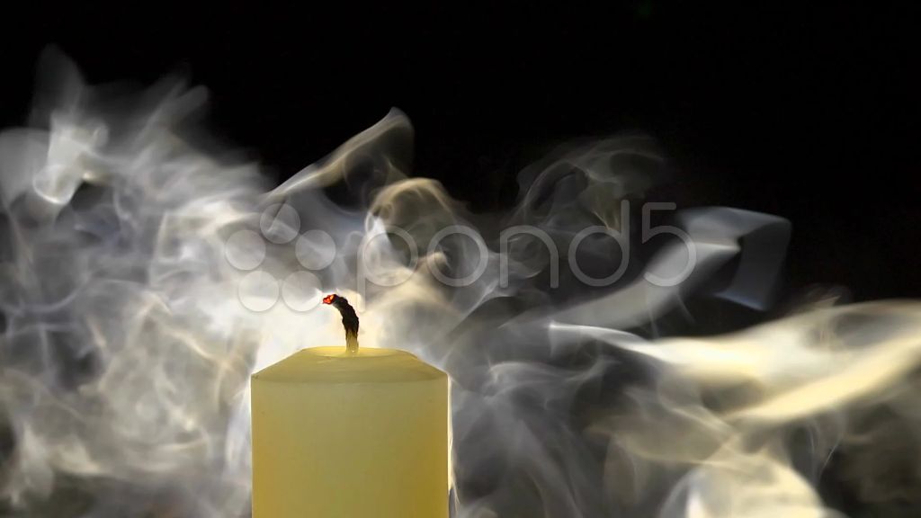 person blowing out candle with smoke drifting