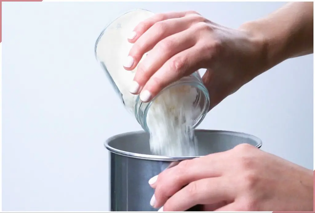 wax being poured into a glass jar