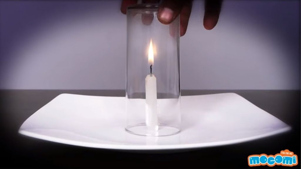 a candle burning inside a glass container.