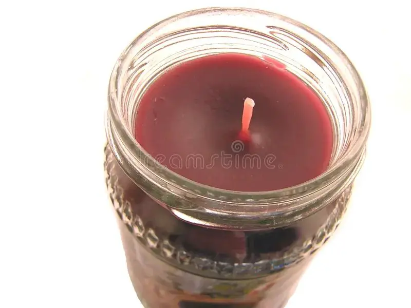 a close up image of a soy candle wax melting in a glass jar with wick