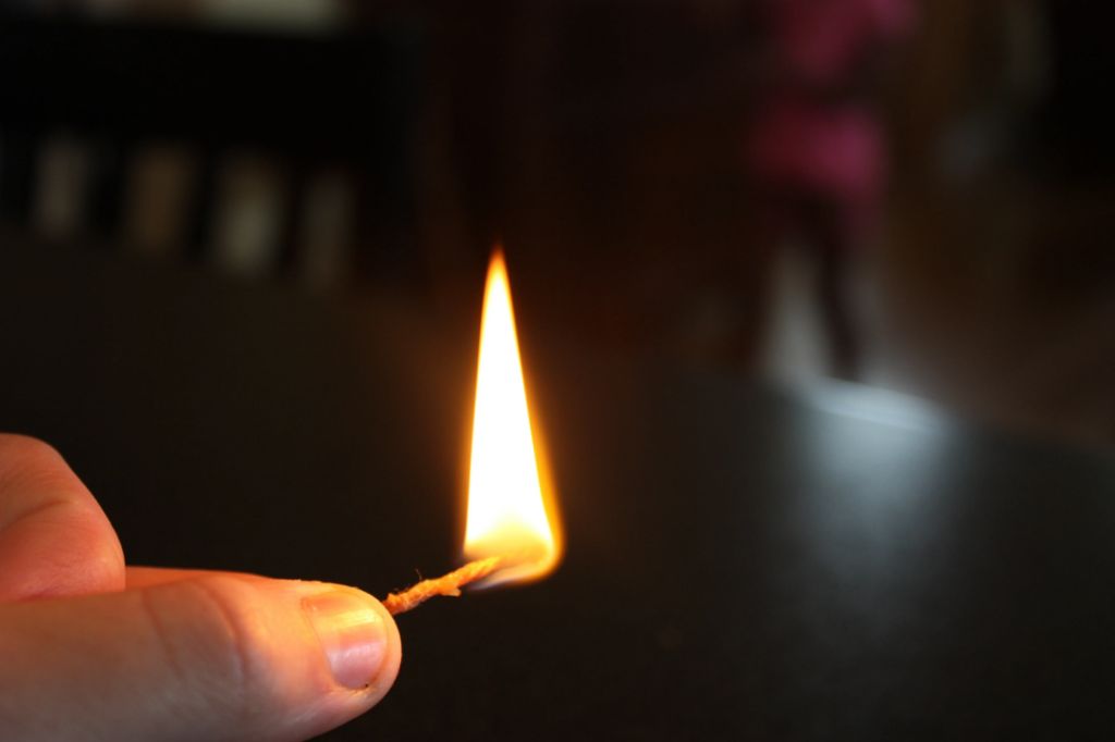 a cotton string wick burning in a candle