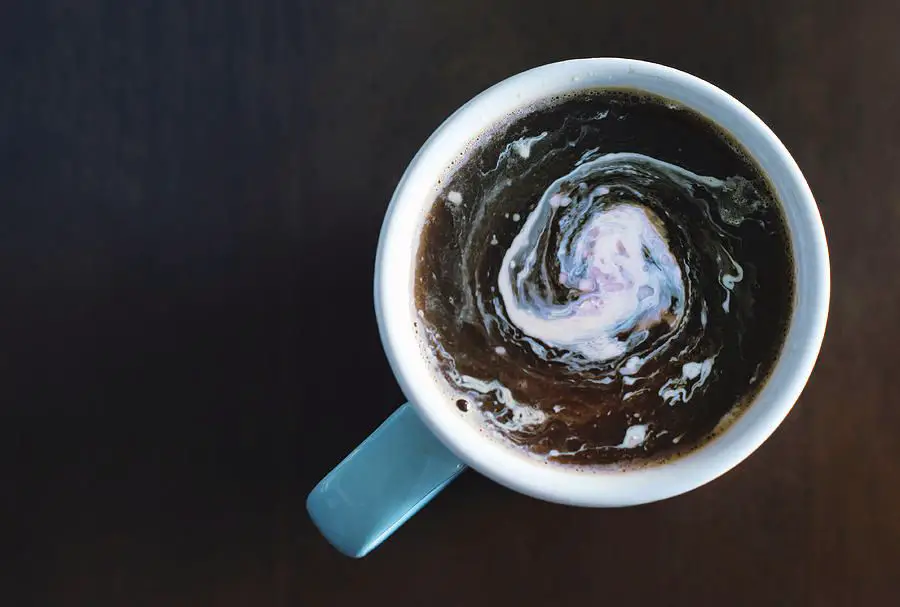 a cup of coffee with cream swirling on the top.