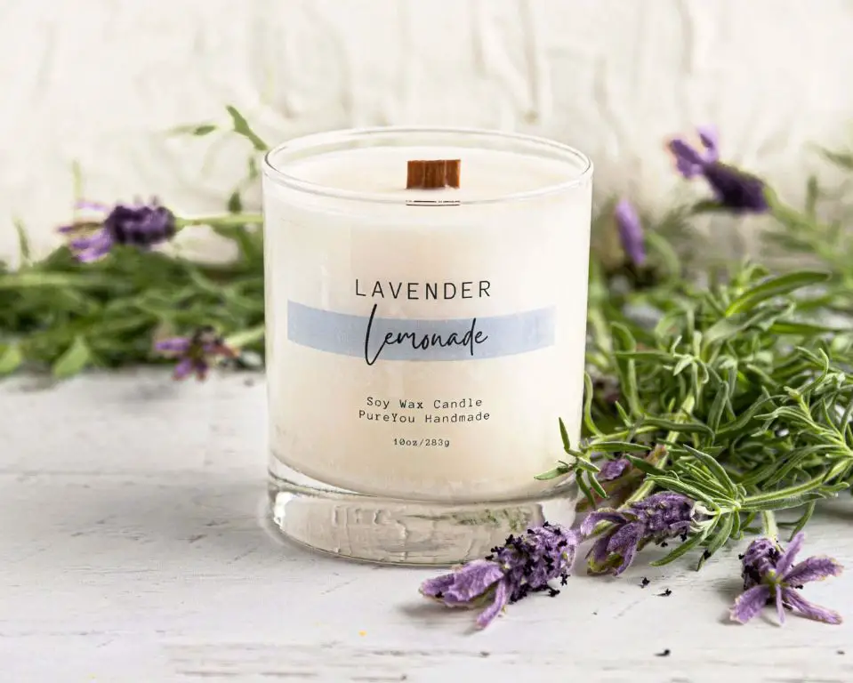 a lavender scented candle burning on a table.