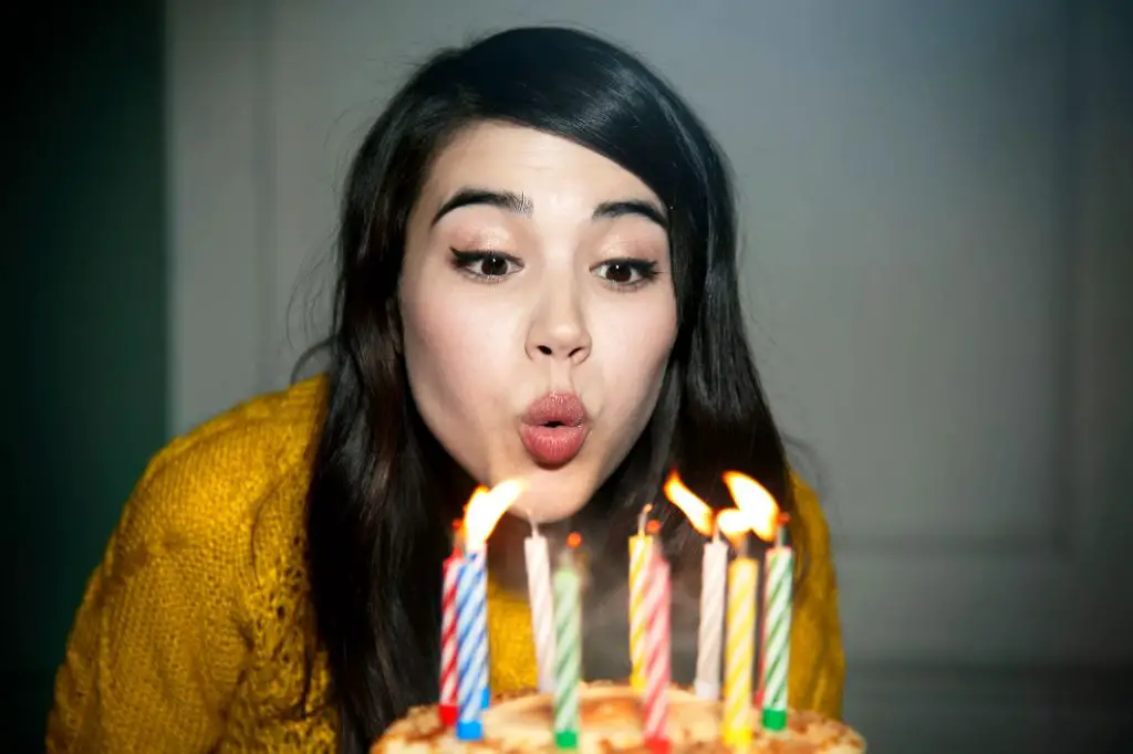 a person blowing out a candle.