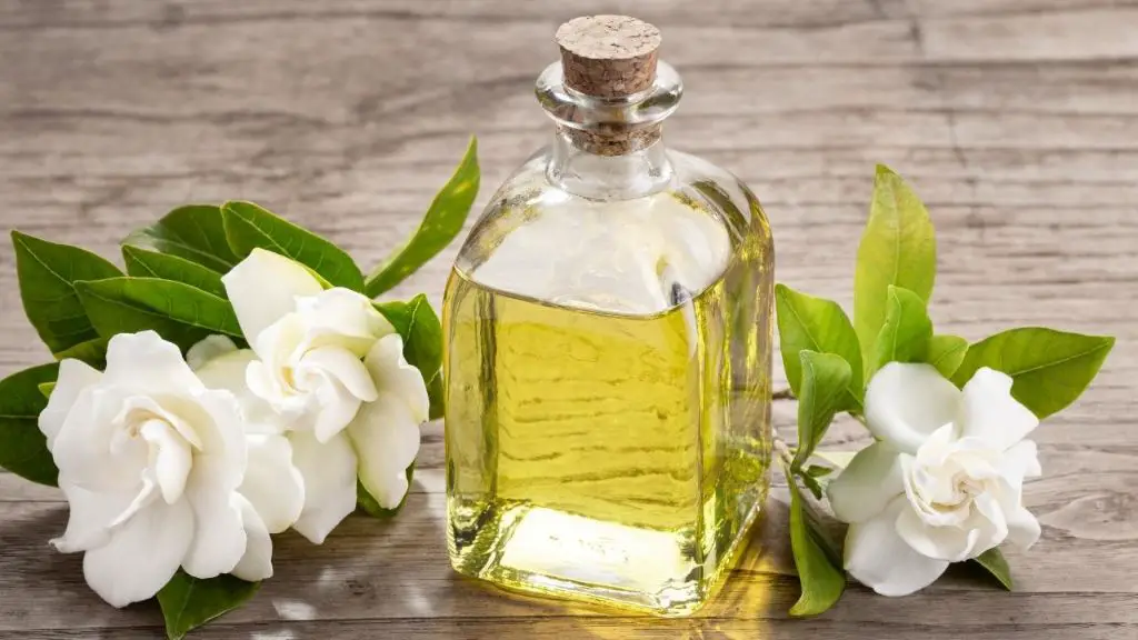 a person inhaling scent from a bottle of gardenia essential oil.