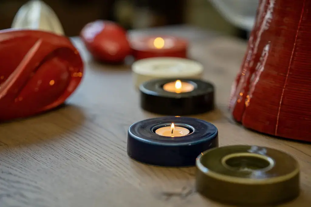 a person lighting a tealight candle.