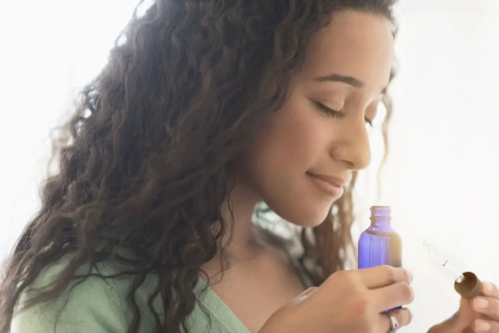 a person sniffing a bottle of fragrance oil and having difficulty breathing