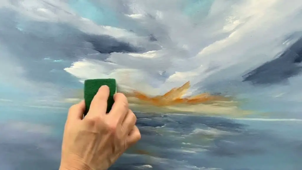 a person using a kitchen sponge to dab paint onto a tea light candle