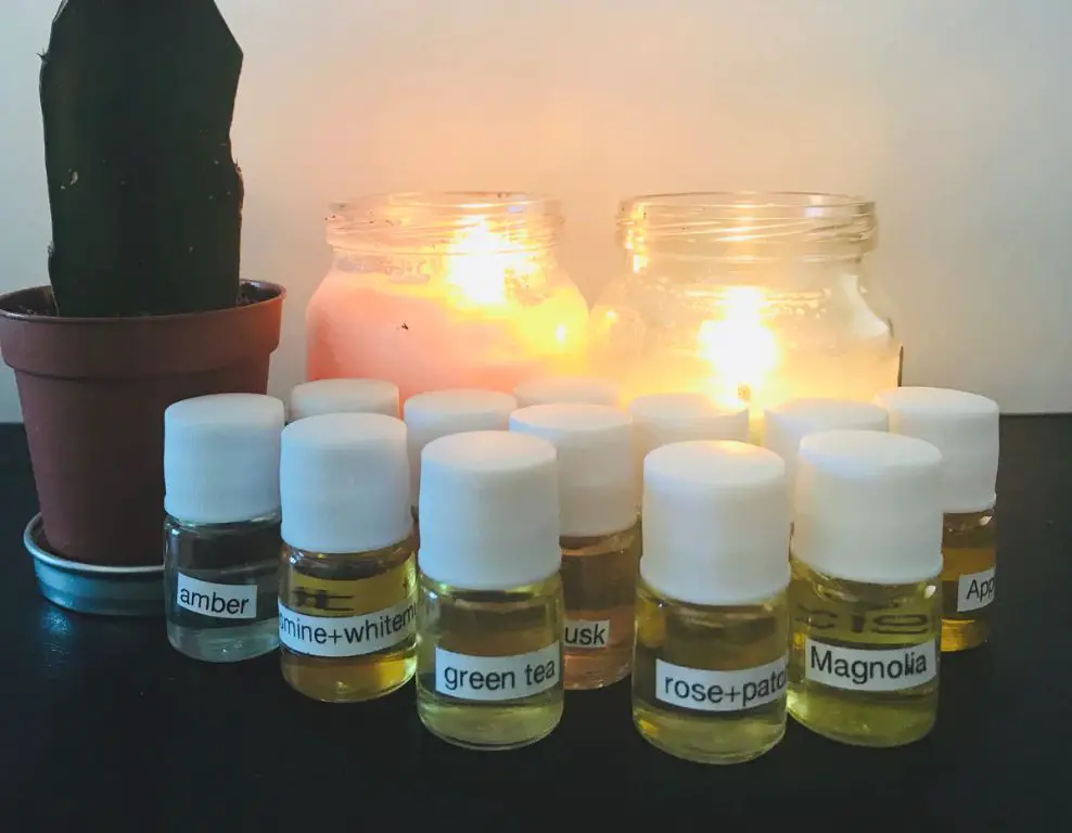 a person wearing gloves carefully measuring out a small amount of fragrance oil to add to candle wax