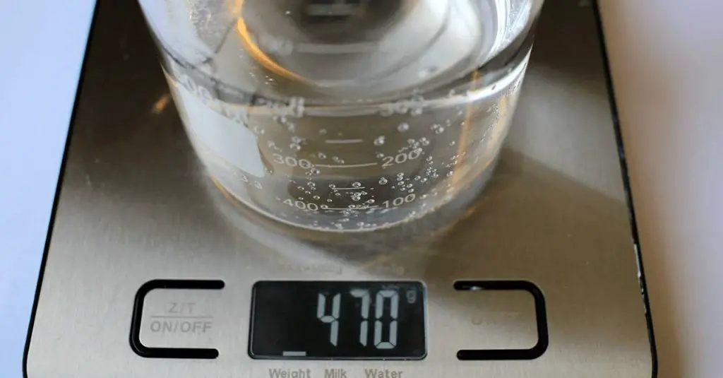 a person weighing candles on a scale to determine the average weight in ounces