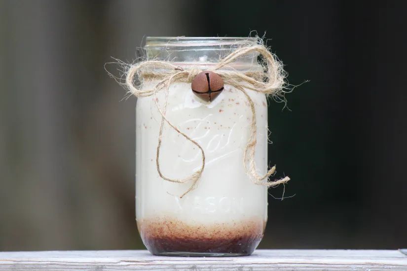 a photo of a mason jar candle with a straight wick placed in the center