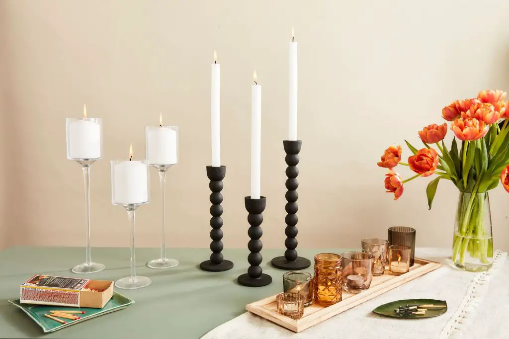 a row of black currant vanilla scented candles on a table.