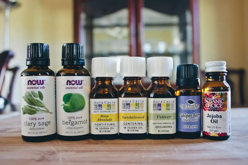 a row of small glass bottles filled with various natural plant oils like jojoba, coconut, and almond oils that can act as musk substitutes.