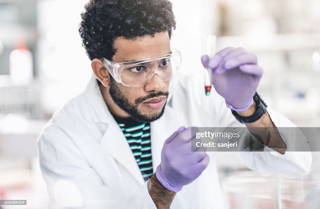 a scientist in a lab coat analyzing the chemical composition of musk in a test tube.