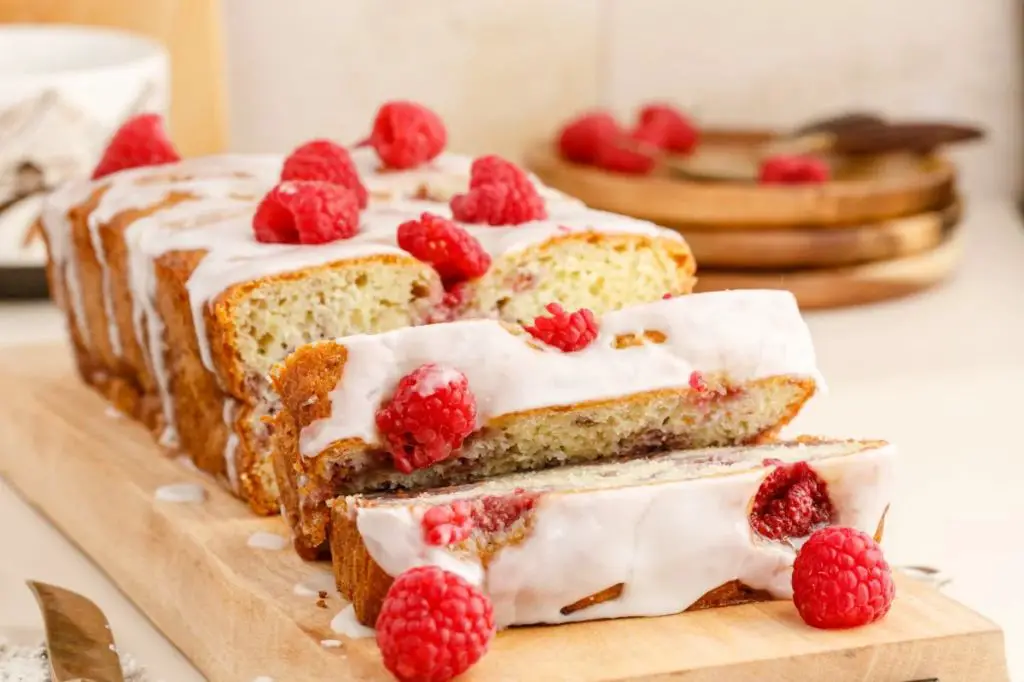 a slice of lemon pound cake plated with some fresh raspberries