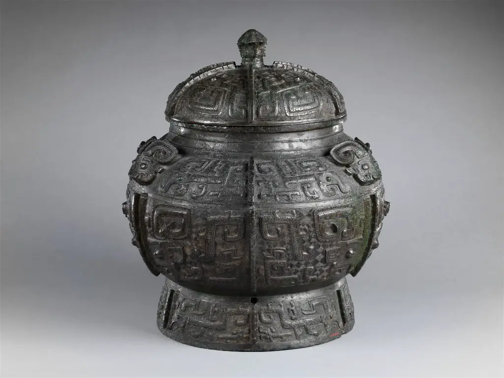 a vintage bronze wine pot from the ming dynasty featuring detailed decorative carvings.