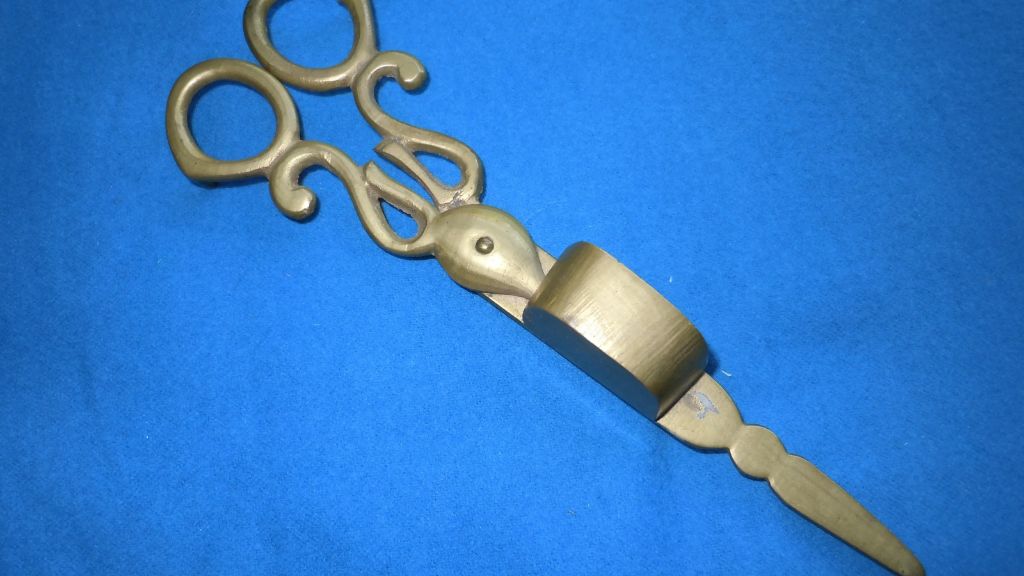 an antique wick trimmer tool used to trim candle wicks.