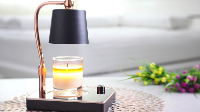 an essential oil candle being warmed on an electric candle warmer instead of being burned