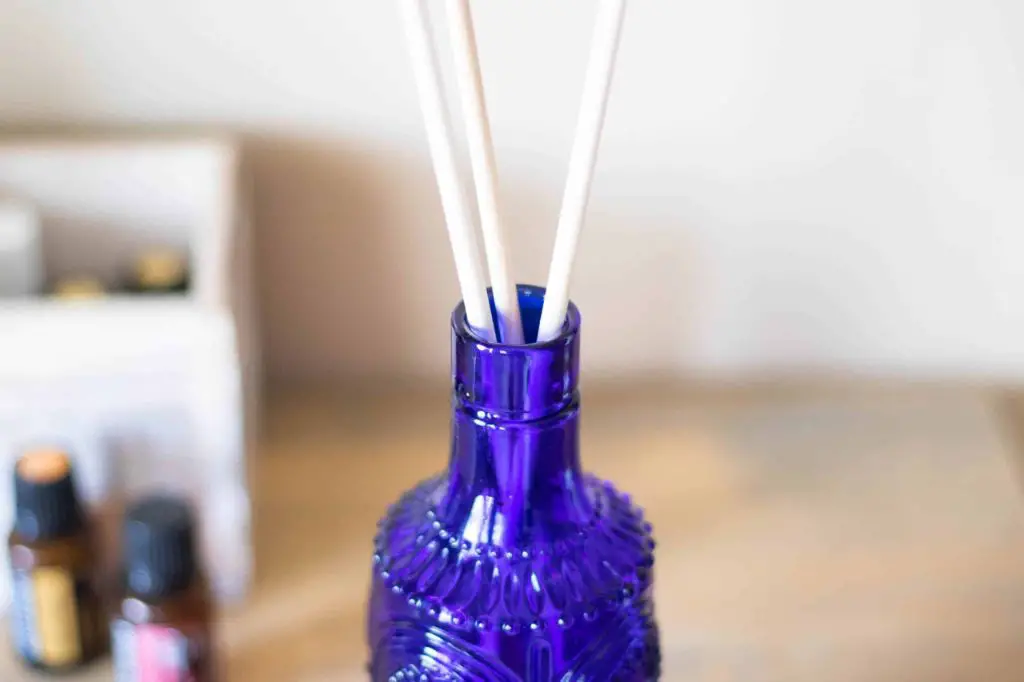 an open diffuser bottle filled with water and several drops of essential oil