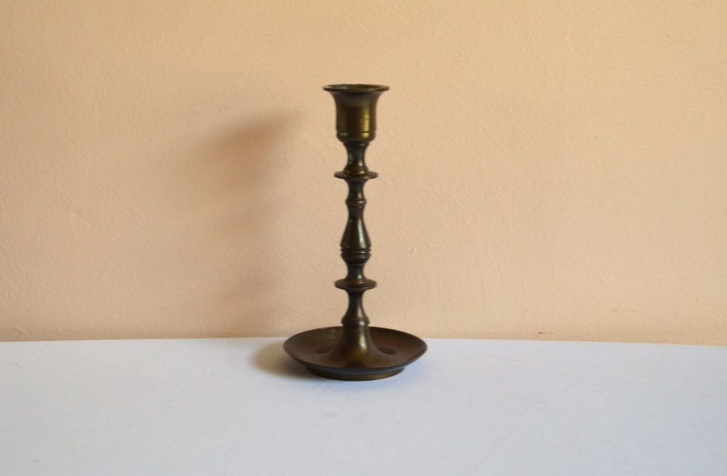 antique brass candlestick with dark patina on table