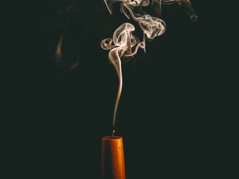 candle releasing fragrant smoke while burning
