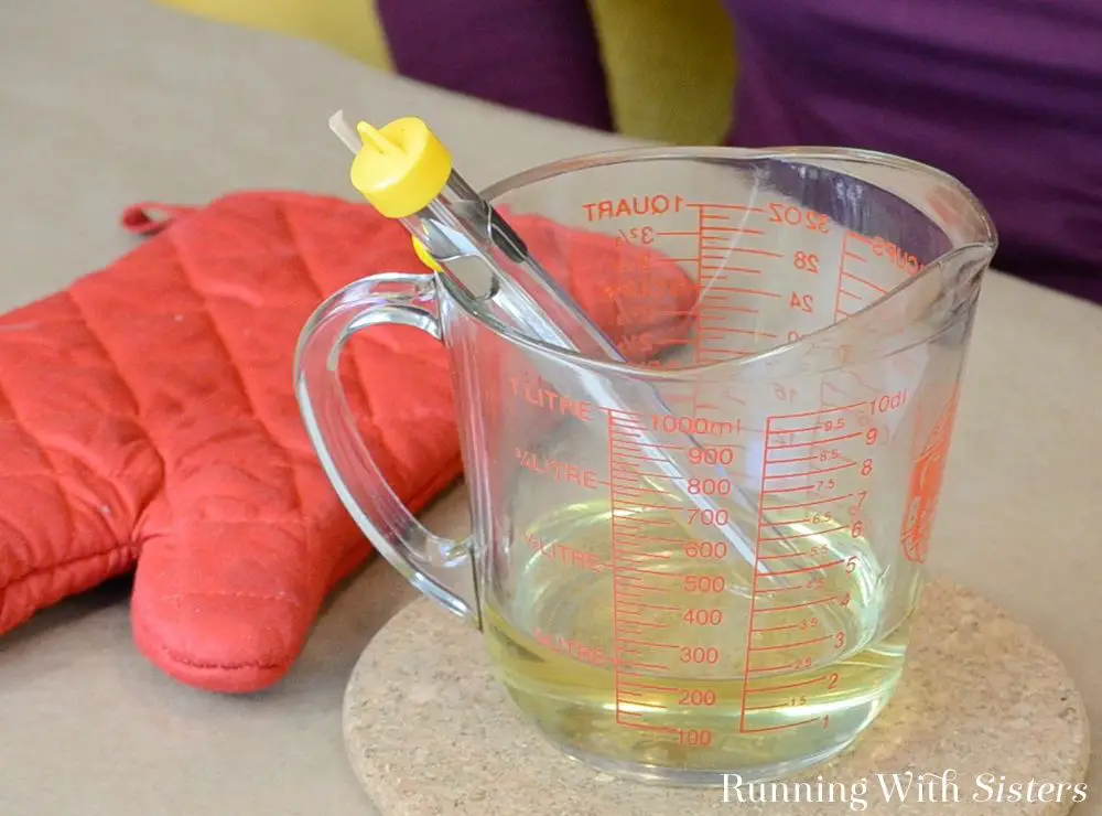 candle wax melting in a glass measuring cup in a microwave.