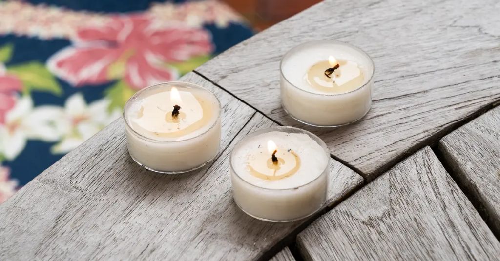 citronella candles burning on an outdoor patio table