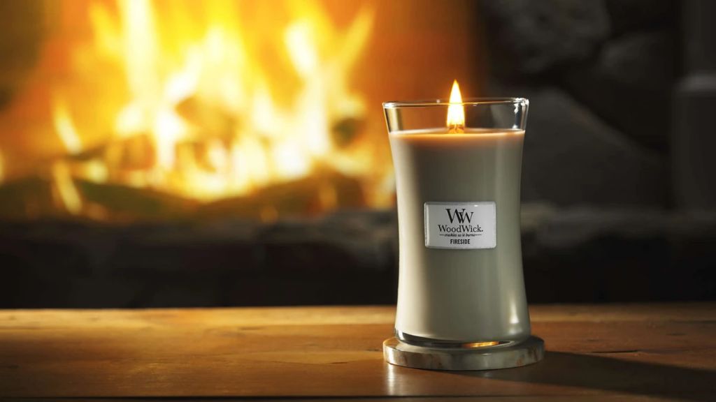 close up image of a woodwick candle burning, showing the wooden wick structure
