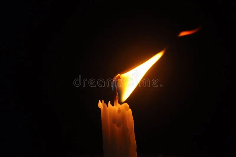 close up of a burning candle with flames visible.