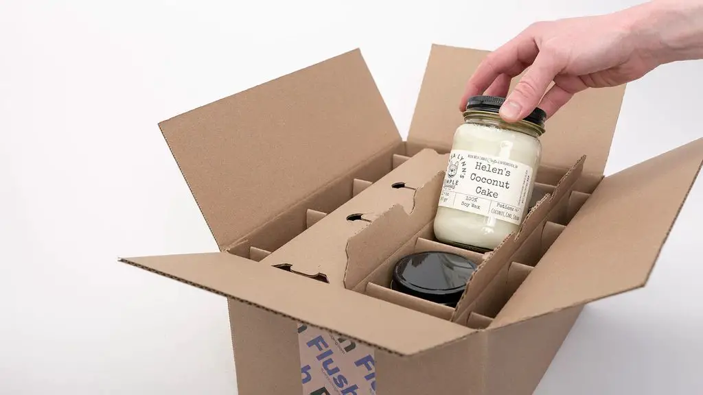 close up of a soy wax candle inside an insulated shipping box.