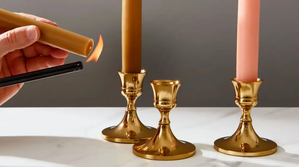 gold antique candlesticks with lit white tapers.