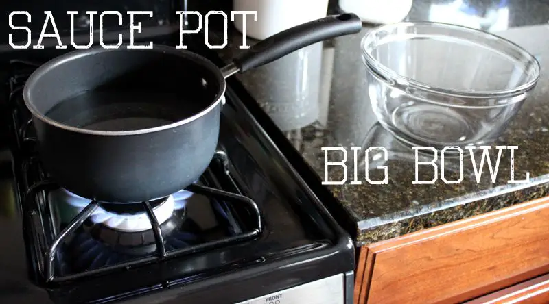 image of a glass bowl sitting on top of a saucepan over a stovetop burner