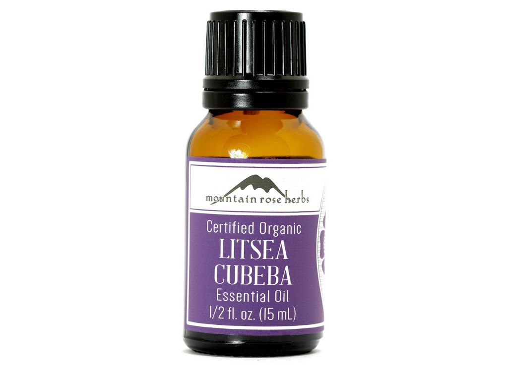 litsea essential oil in a glass bottle with a dropper on a wooden background