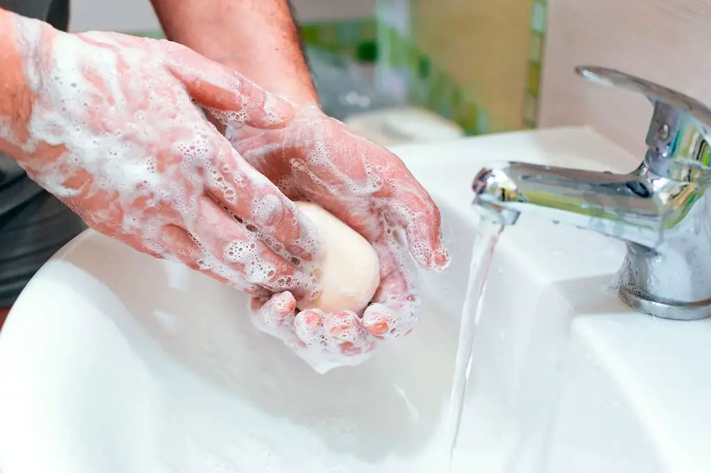 man washing hands with bar of soap