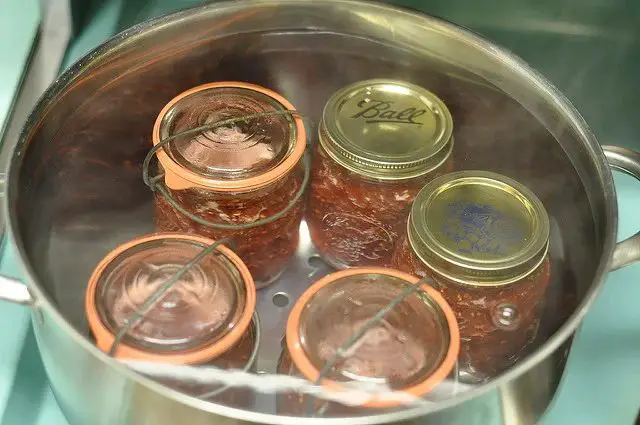 old canning jars with rusty lids and one jar with a bulging lid