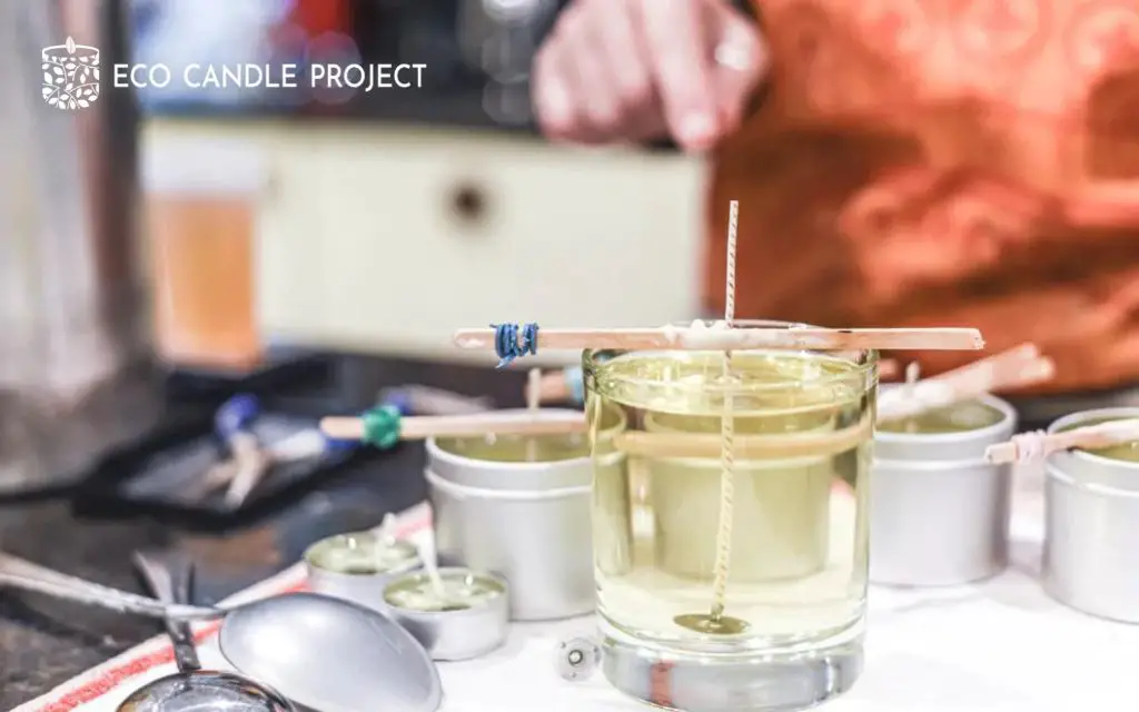 person adding fragrance oil to melted wax.