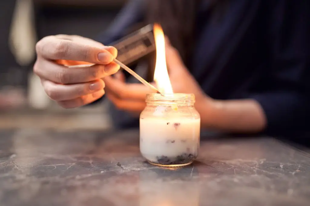 person cleaning inside of glass jar before candle making