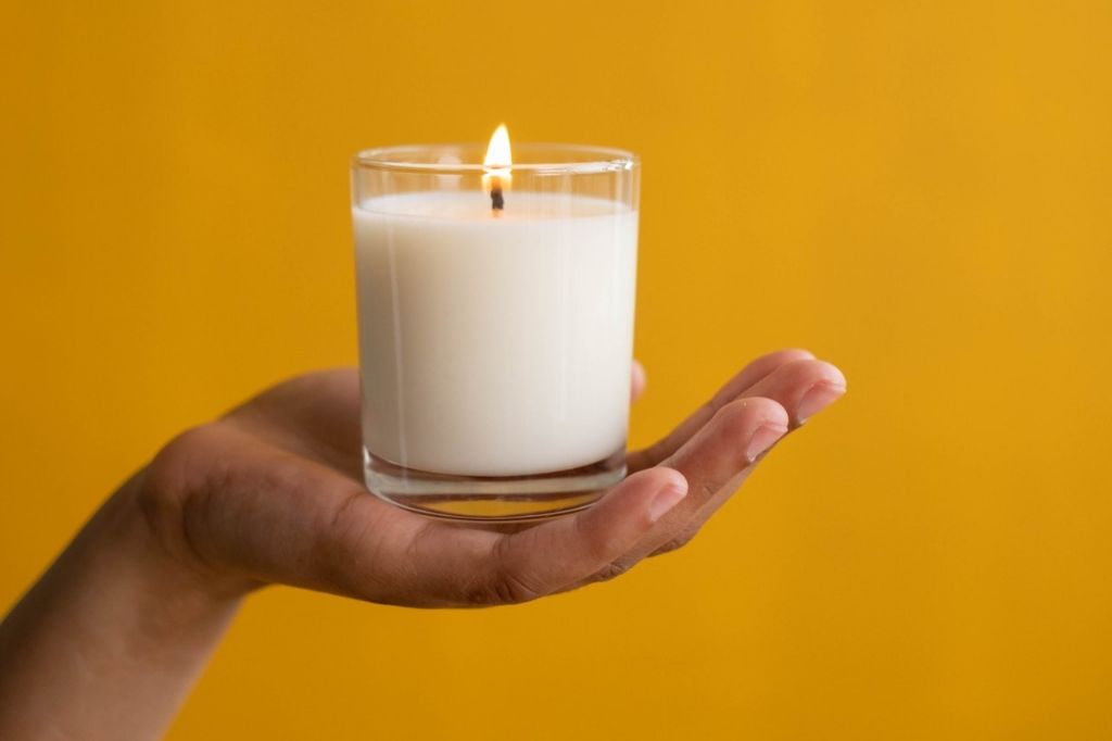 person discarding unevenly burned candle