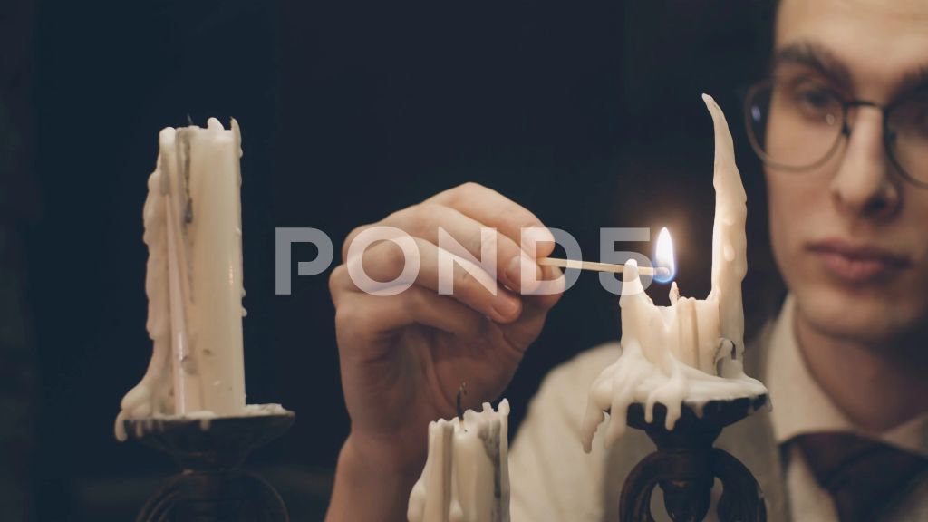 person lighting candle with match