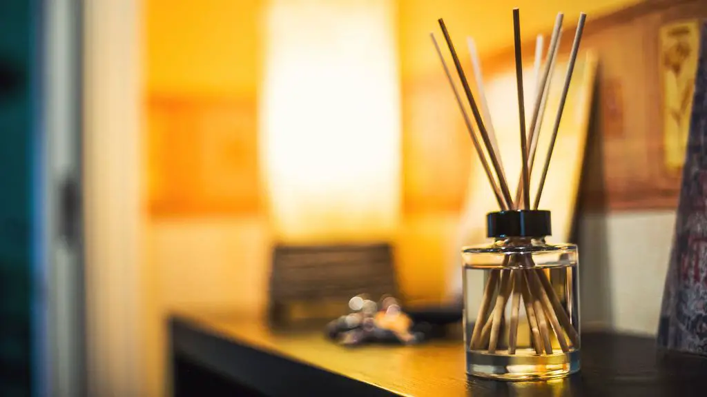 person smelling a diffuser with multiple sticks