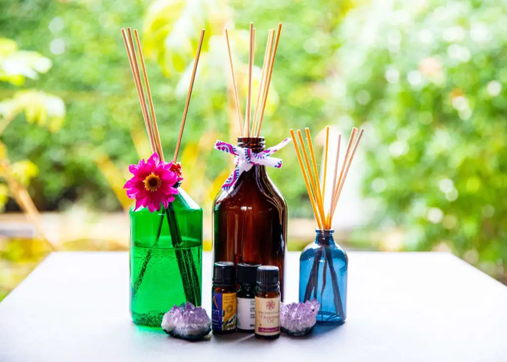 person smelling essential oil bottle for reed diffuser