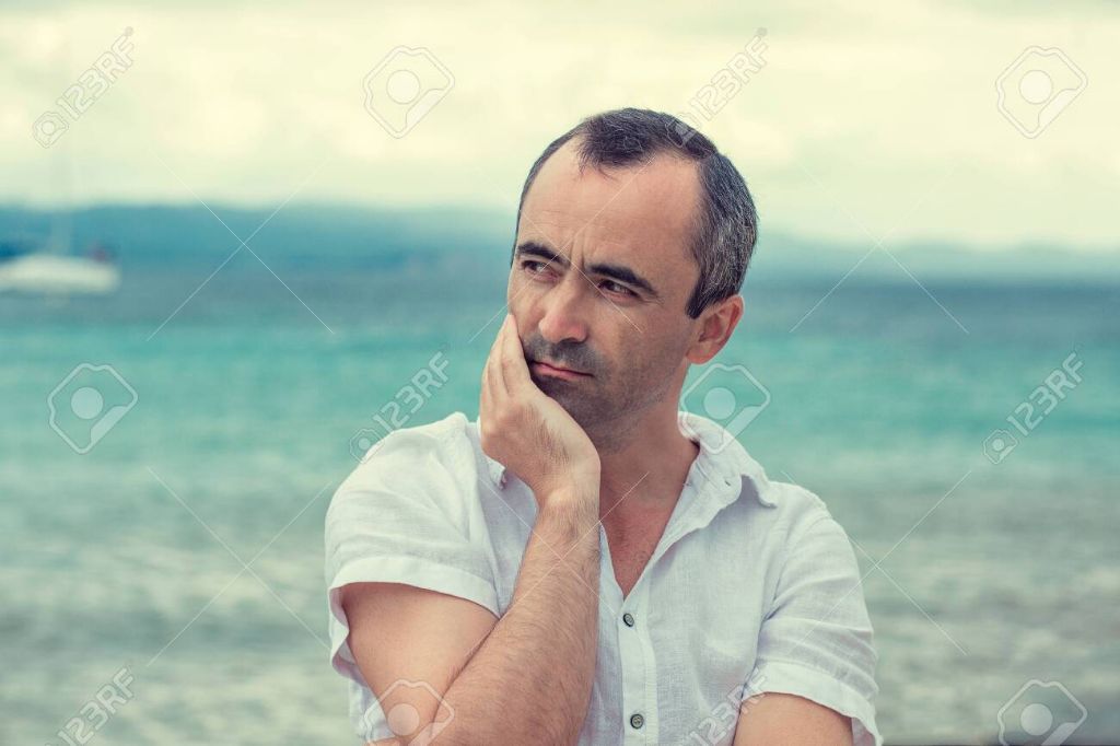 person taking a deep breath of ocean air while standing on the beach