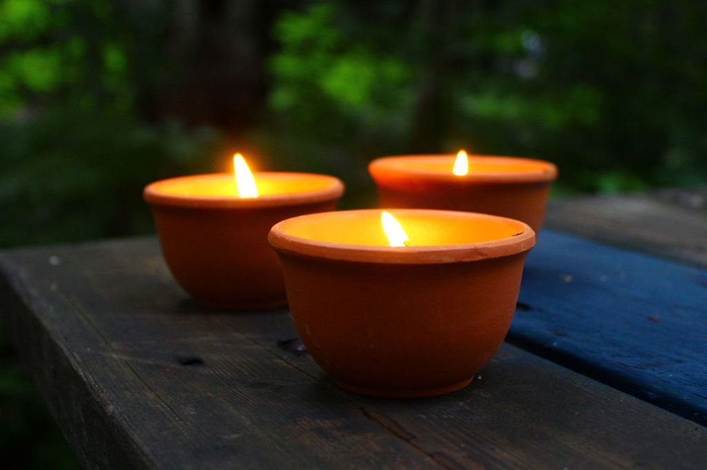 person using a citronella candle outdoors