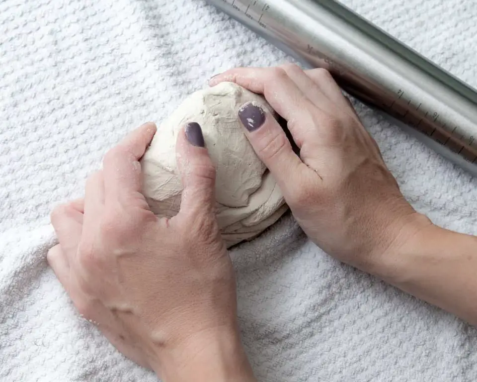 person's hands molding air dry clay