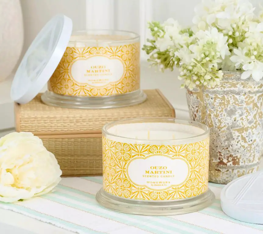 row of white and gold scented candles with price tags.