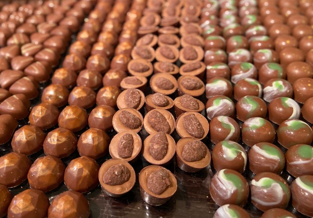 rows of chocolate truffles coated in shiny paraffin wax.